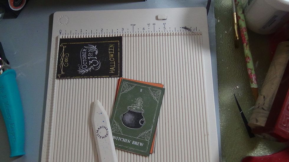 I began embellishing my pages, here I created a small waterfall with the tiny tags from one of the sheets of paper. I just scored it @ 1/8 in