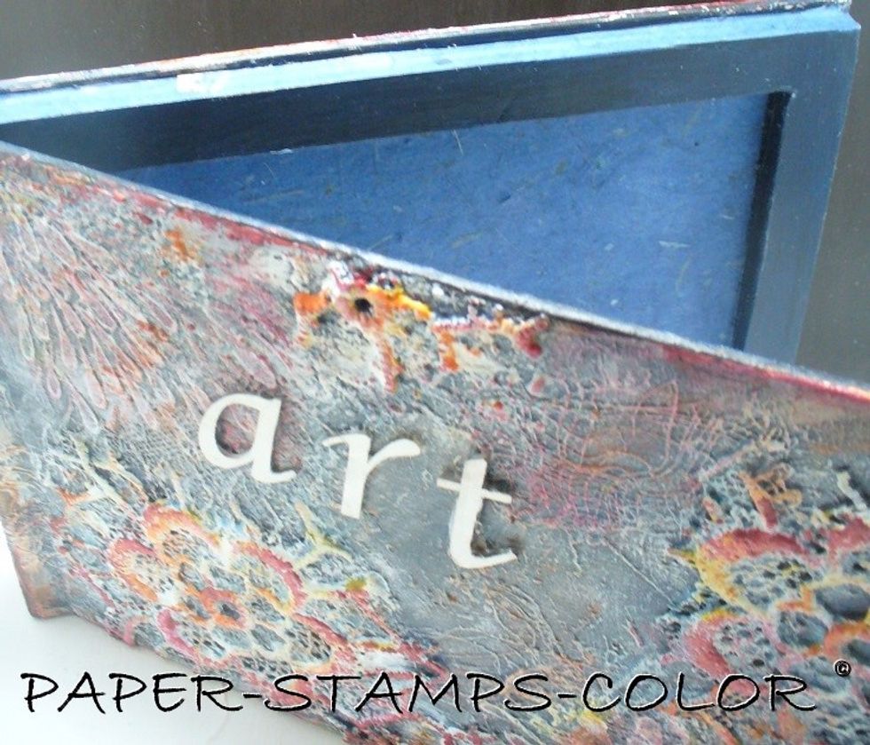 I cut and glued the inside of the book to create a bookbox (Google on "bookbox from book") and painted it with black gesso and Blue Topaz Gemstones. After that dried, I adhered some handmade paper.