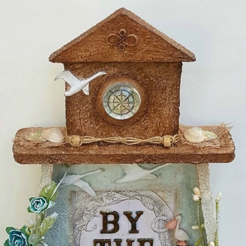 I cut the compass out from nautical themed paper and placed it behind the Melange pebble.