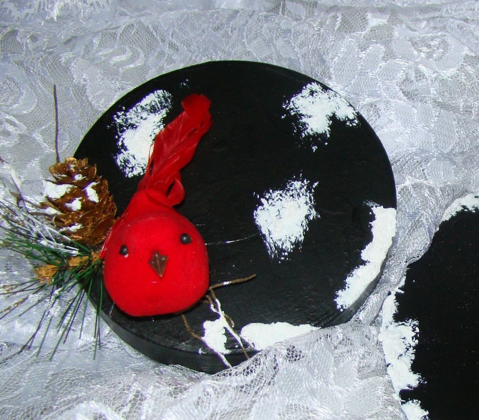 I decided I wanted to decorate the to of the hat. I glued a red cardinal atop some twigs. Added pinecones and greenery. Add Snow Tex along the sides of the top hat.