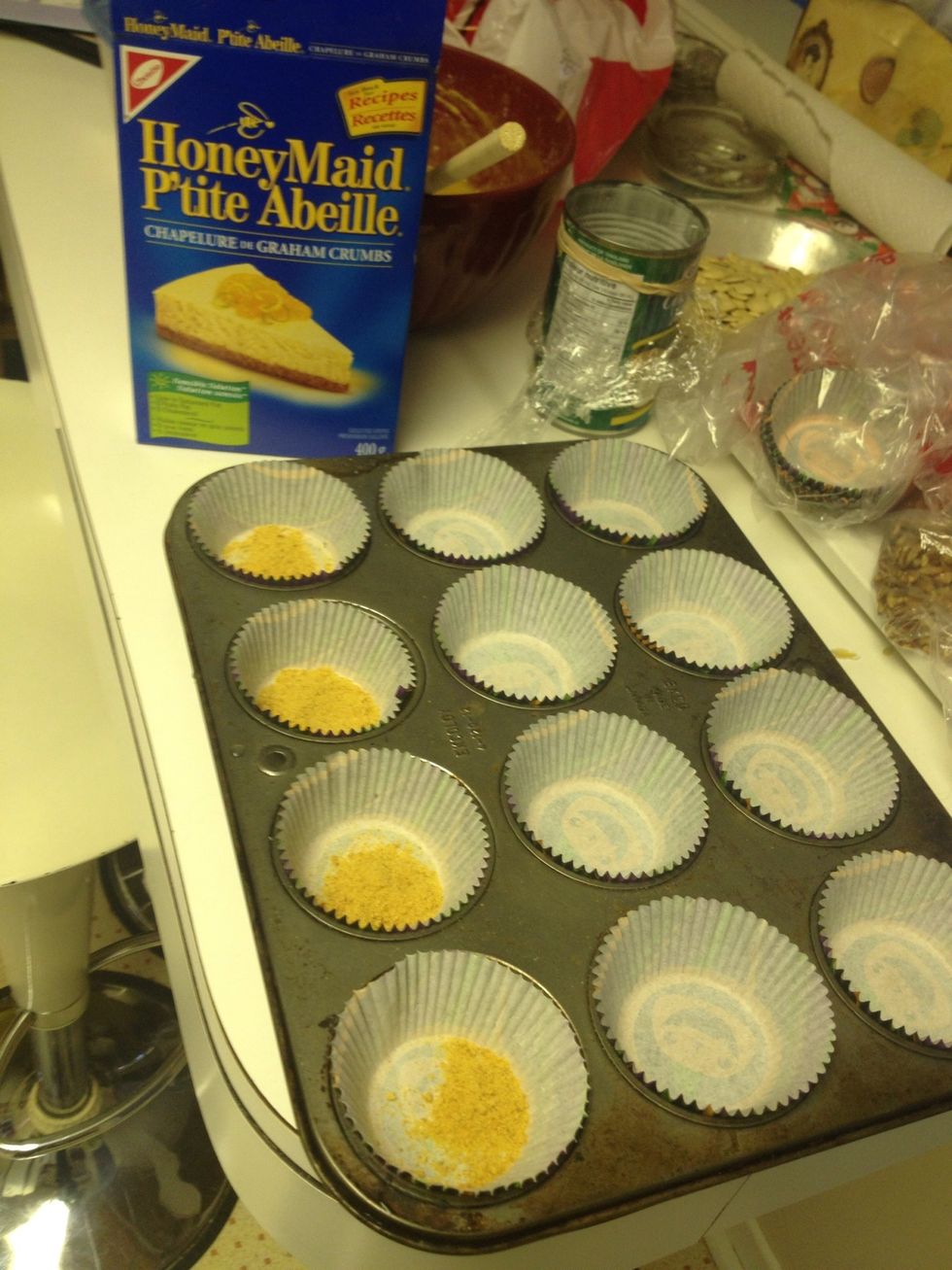 I don't want a crust on these, but I wanted something LIKE a crust, so I put a few graham crumbs in the bottom of each cup, like so.