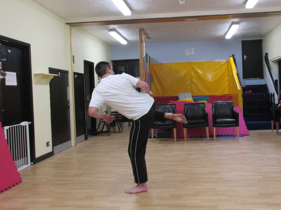 I draw the rear leg forward preparing to sweep across the target with the sole of the foot. My hips begin to turn. I keep looking over my shoulder at the target. My leg is tucked.