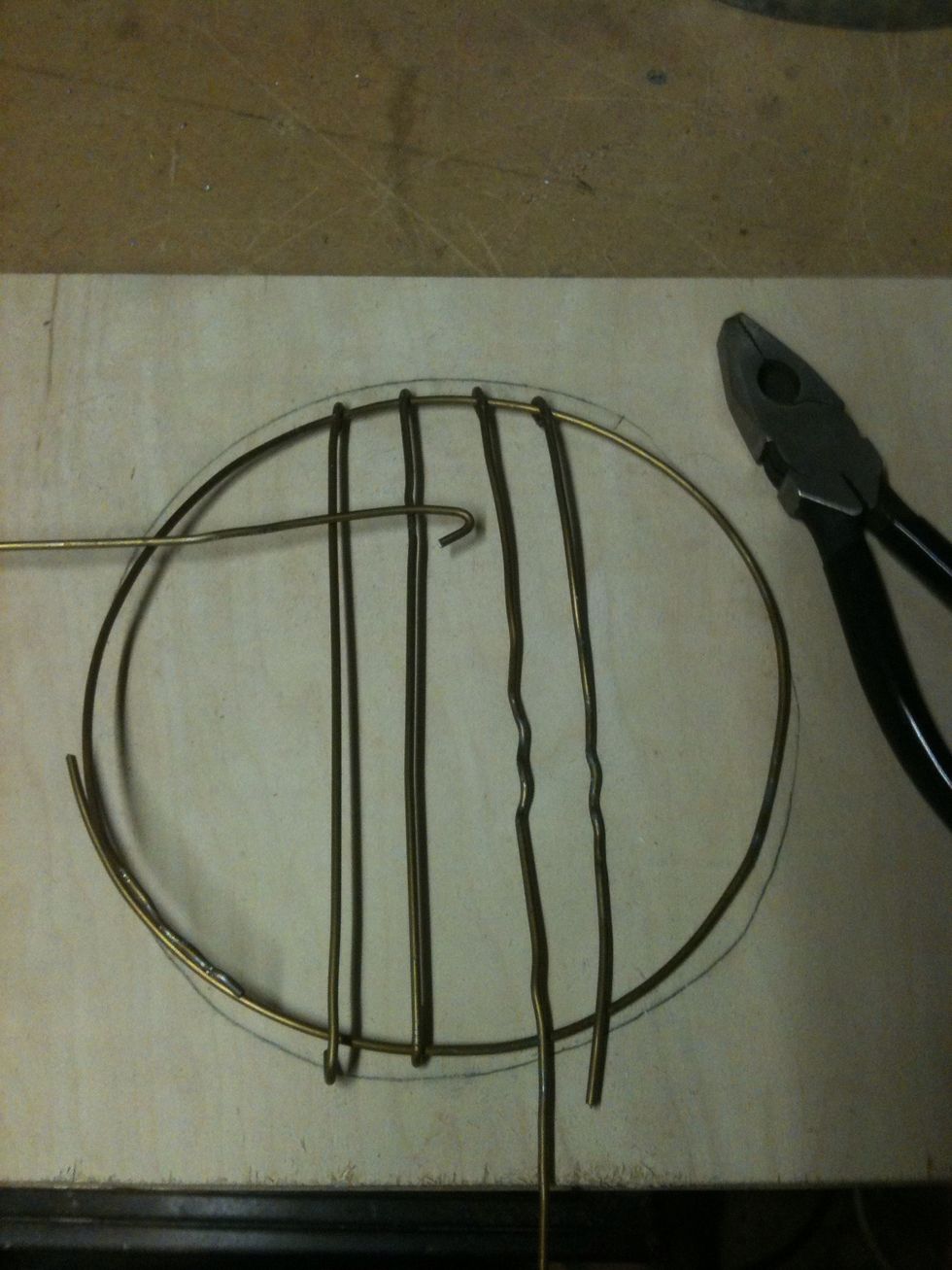 I drew a 7" circle and bent the hanger around the circle. Then start wrapping wire around the circle in strips hooking one side first.