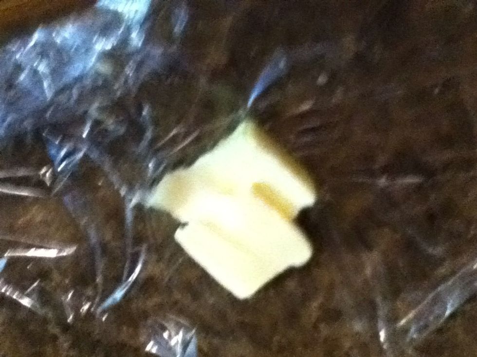 I find it easiest to put a little butter on some plastic wrap to grease the pan. No mess on your fingers.