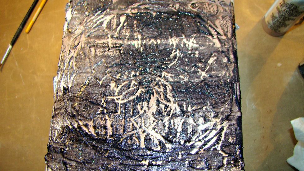 I first took the black paints and swiped over the high parts of the box and using a baby wipe, removed what I didn't want. This allows the black paint to get into the crevices nicely.