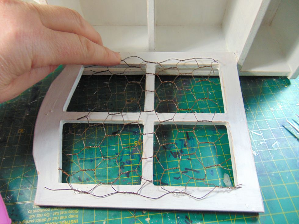 I fitted some chicken wire to the inside of my door window. My stapler wasn't working so I used some hot glue instead. I used a piece that was smaller then the window to keep the whole shabby look!