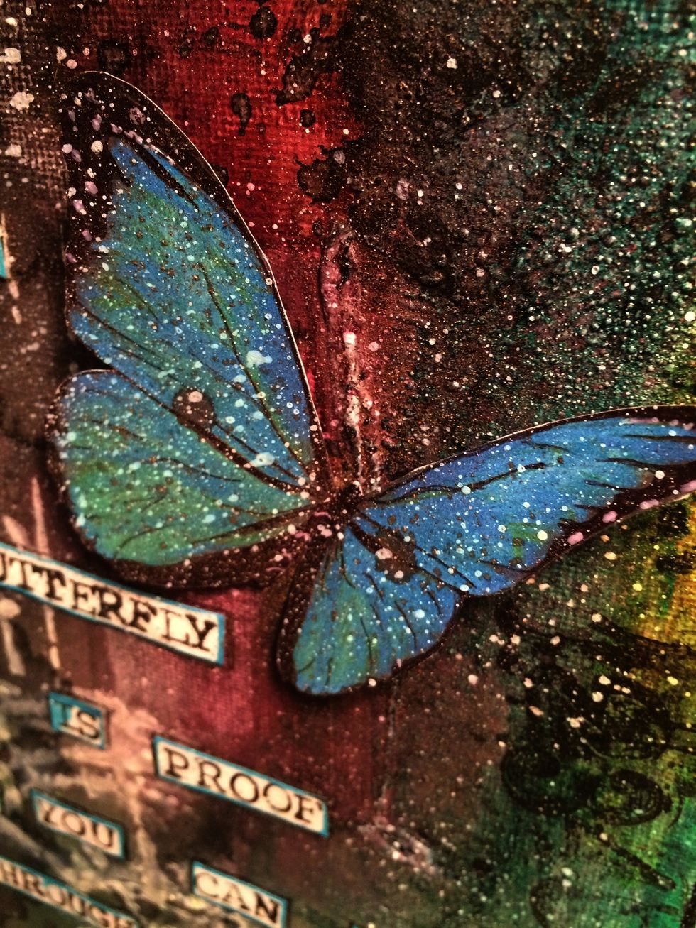 I glued my butterflies in place then I dumped some of the white ink onto my craft mat. Using a toothbrush I did a splatter of white ink onto the canvas and butterflies. I like a grungy look..
