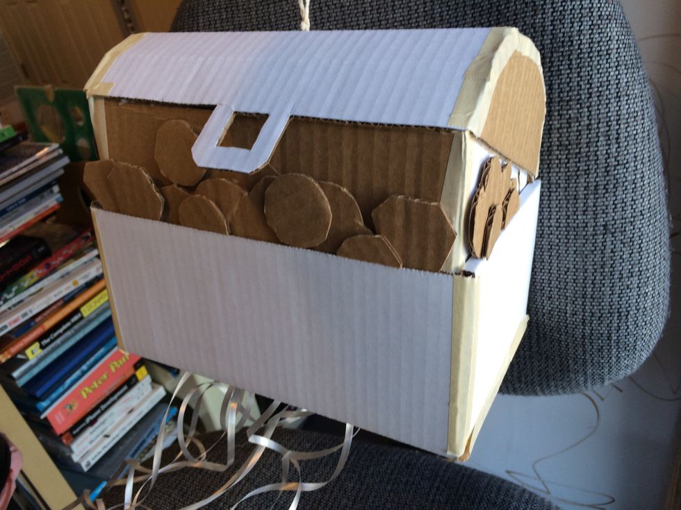 I glued on circles and gem shapes to the front and sides where the box looks open, and half-circles on the sides of the lid to make it curved. Add a string through the top to hang it with.