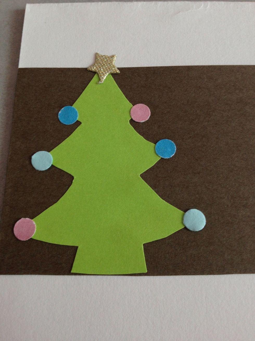 I had a star ribbon, so I cut off a star and glued it to the top of the tree. You could paper punch a star out, or use other shapes like an angel!