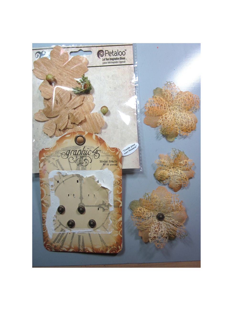 I had some nature Petaloo flowers that I layered together using a Graphic 45 metal brad. I just love the finished look of the flowers. They match the sea theme so well.