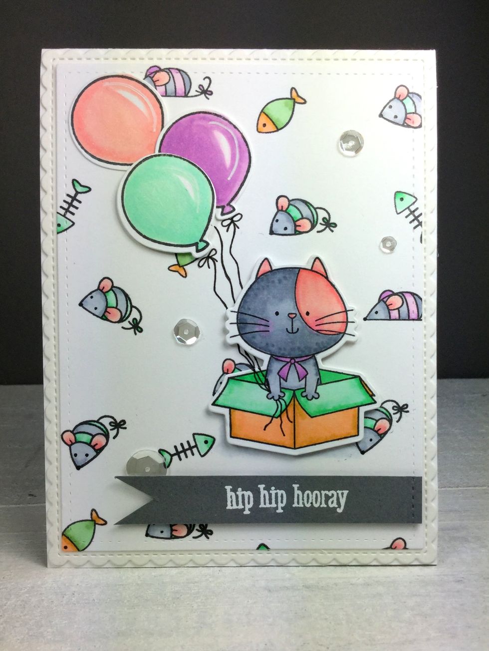 I have drawn a few strings on the balloons. Colored all the little eyes with a black Gelly Roll pen to let them pop. And added the grey banner. Love it!