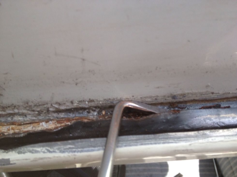 I have no idea what this tool is called. It looks like a bent over screwdriver. There is a metal "lip" that you need to bend over to free the rim of the roof, that is secured by it.