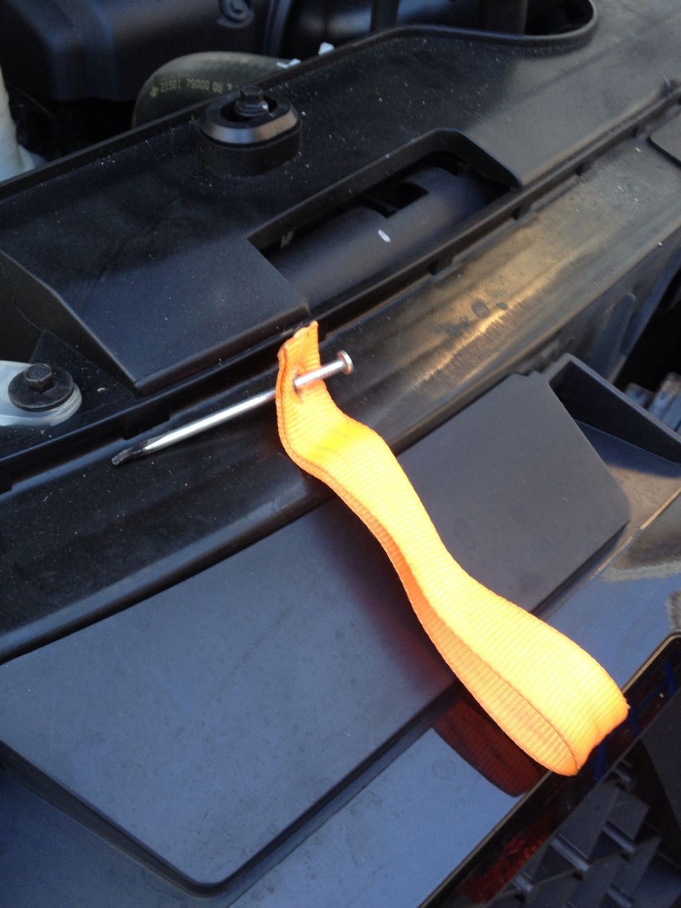 I heated the nail and pushed it through the nylon strap to make a hole for the bolt to pass. You may need to heat the ends where you cut to melt it together so it doesn't fray