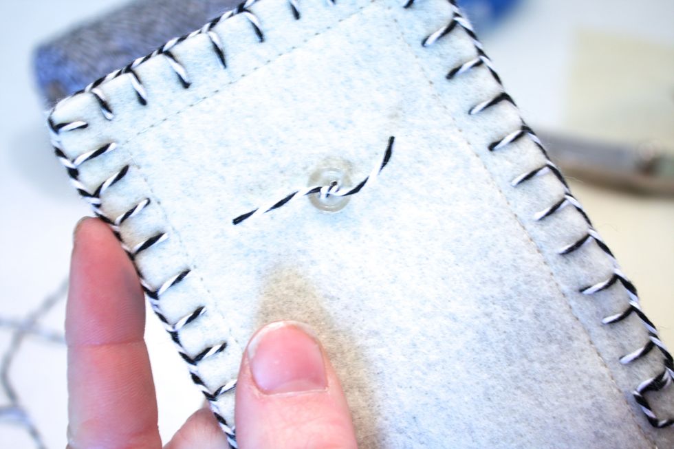 I just ran it through once, then through a smaller button on the inside to help secure it. Then tied my twine in a knot