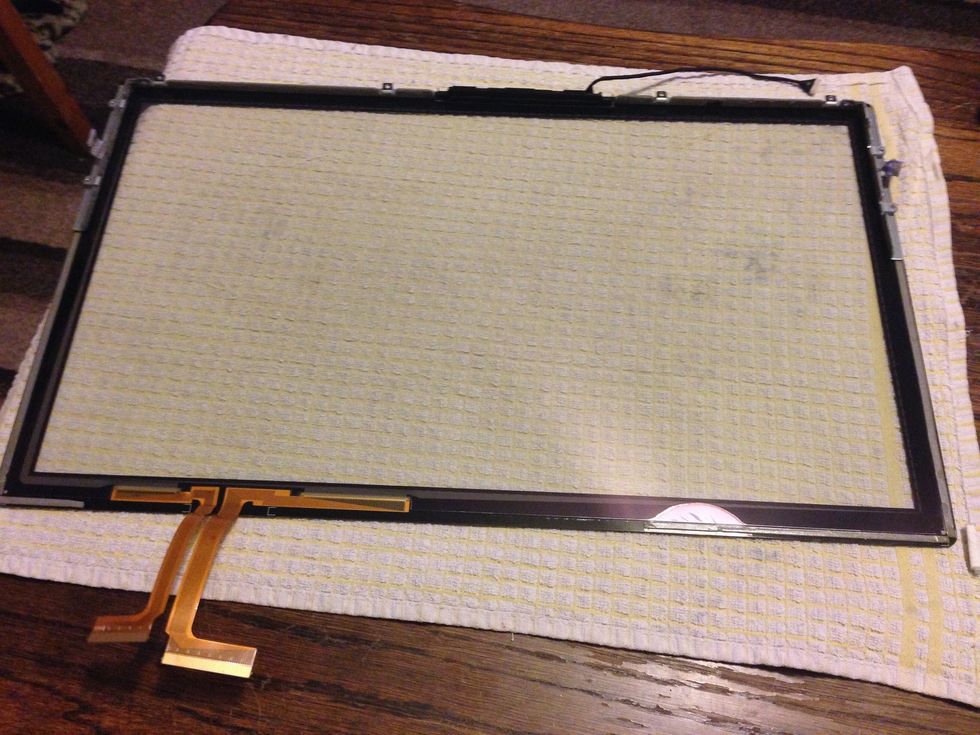 I left the top metal angles on but had to first ease away the left and right edges. Then with the screwdriver ease then LCD down away from the top metal angles. Be extra careful with the ribbon cable.