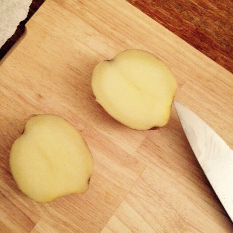 I like to leave the skin on, if you want to peel them, do it before this step. Halve them.