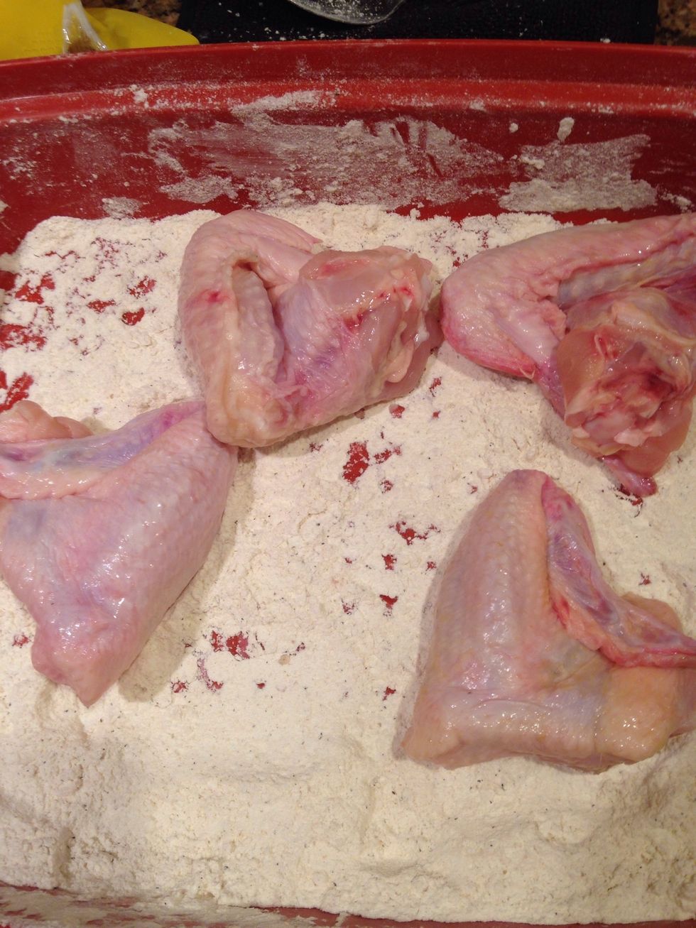 I like to place the chicken into a Tupperware dish that has a pretty deep depth and a sturdy cover because I shake it to get it coated in flour evenly.