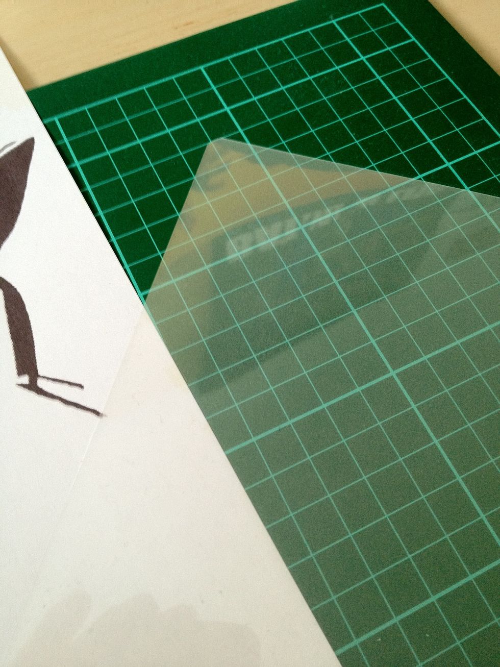 I'm going to cut my stencil into this piece of plastic. I'm just using a laminator sheet but any transparent plastic sheet will do.