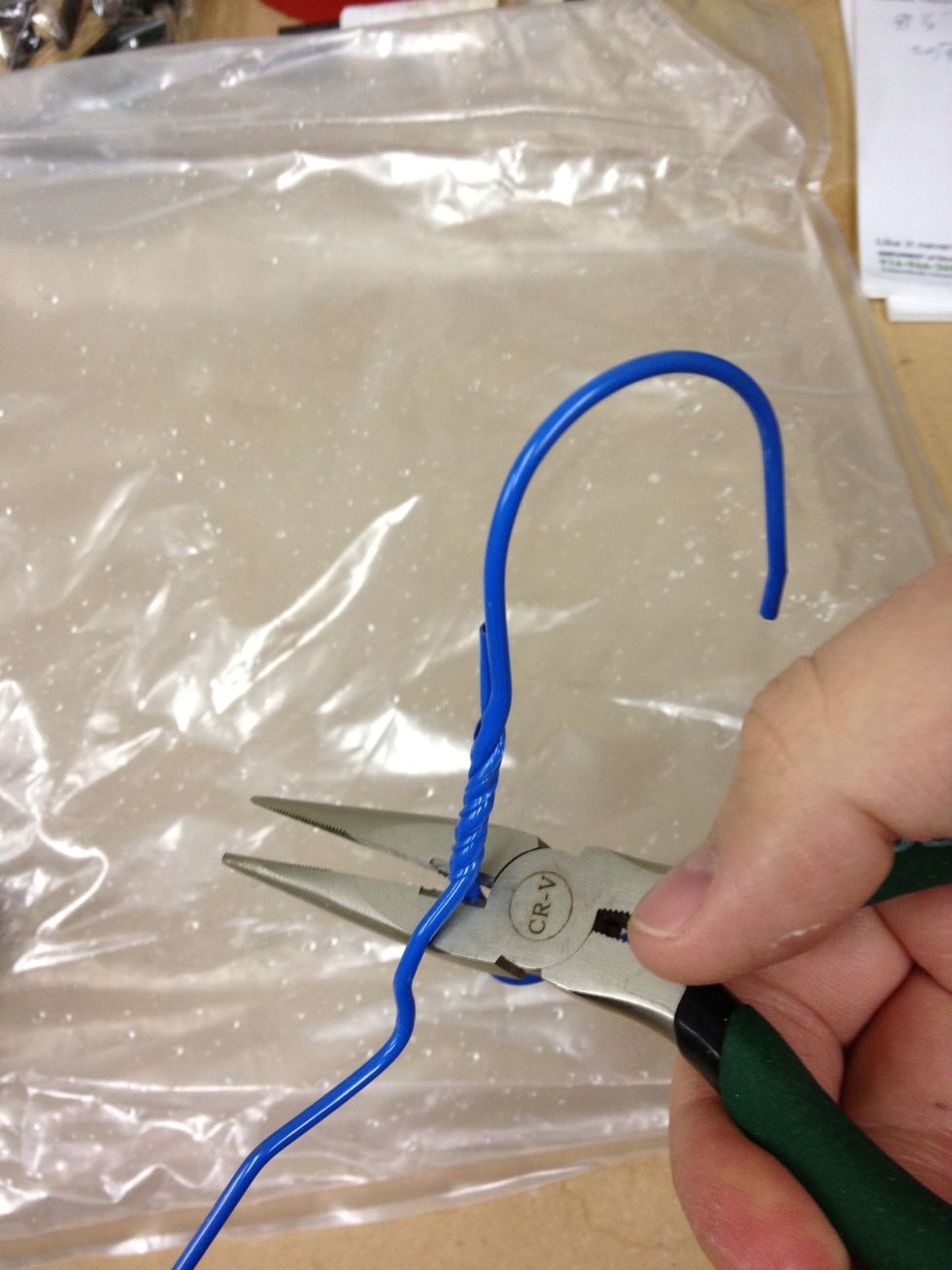 I'm going to use a wire clothes hanger to suspend the bag full of water. First, clip the hanger near the hook with your needlenose pliers.