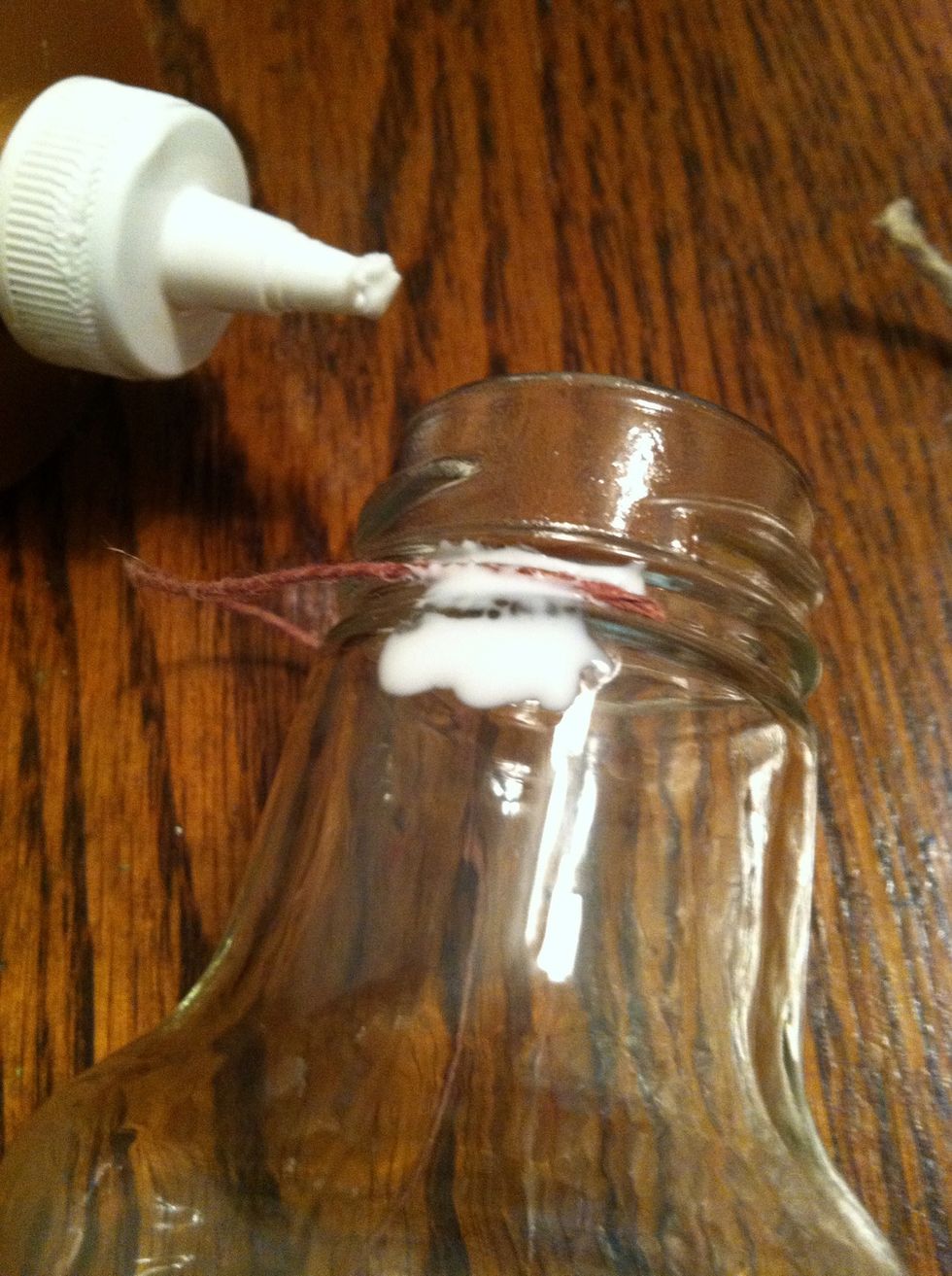 I'm leaving the top alone because it'll be covered by the flowers. Choose a place to be the back, I chose the seam so I would remember easily. Place a dot of glue and the end of your string of choice.