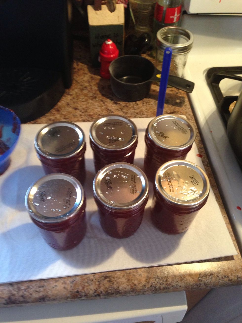 I'm using an old photo here, use a damp paper towel and wipe the lip of the jar clean, then put the lid on the jars and put the ring on securing the lid. You want to be finger tight.