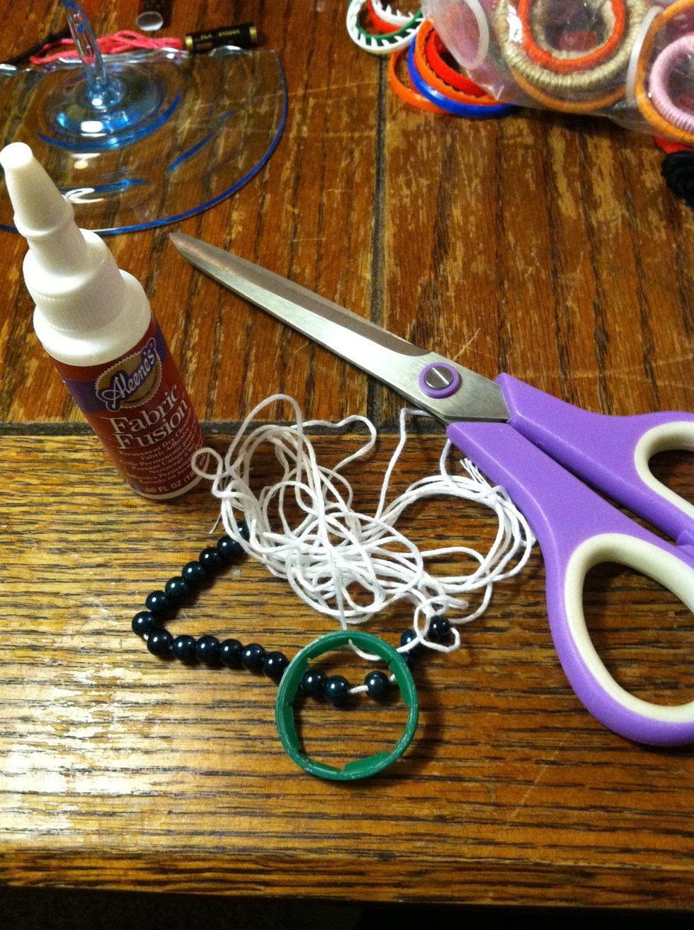 I'm using embroidery floss (iris brand) and I've already strung my beads, which are just old plastic ones from some costume jewelry. But these are the supplies I'm using.