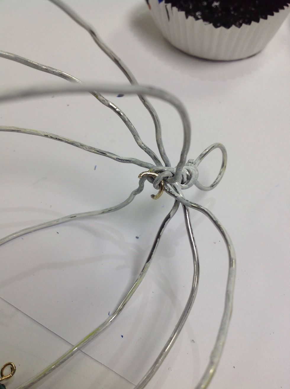 I'm using some wire rings off a Brocken necklace to attach my bird. Use pliers to attach the bird to the cage.