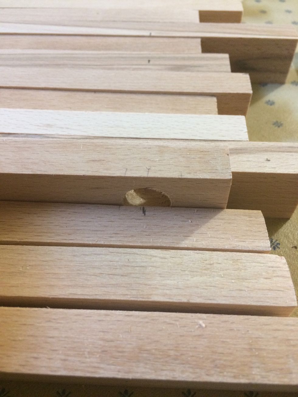 I made a mark where the hole is so that I can make holes in the sticks beside the hooks. That's where the dowel will go through.