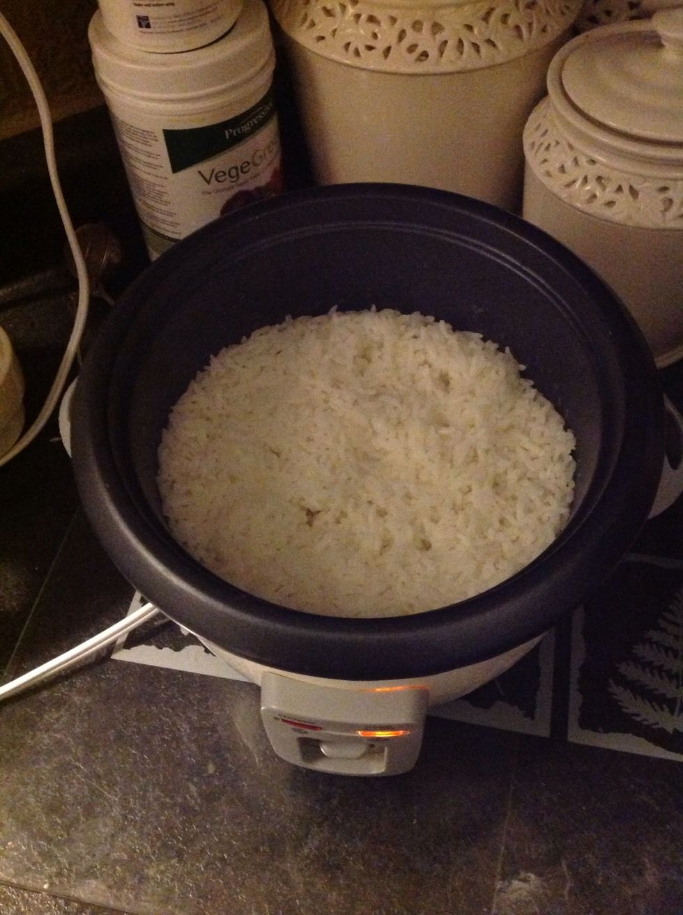 I make sure to rinse my rice at least three times under cold water before cooking it. Put 1 cup of rinsed rice 1 1/2  cups water in a rice cooker.