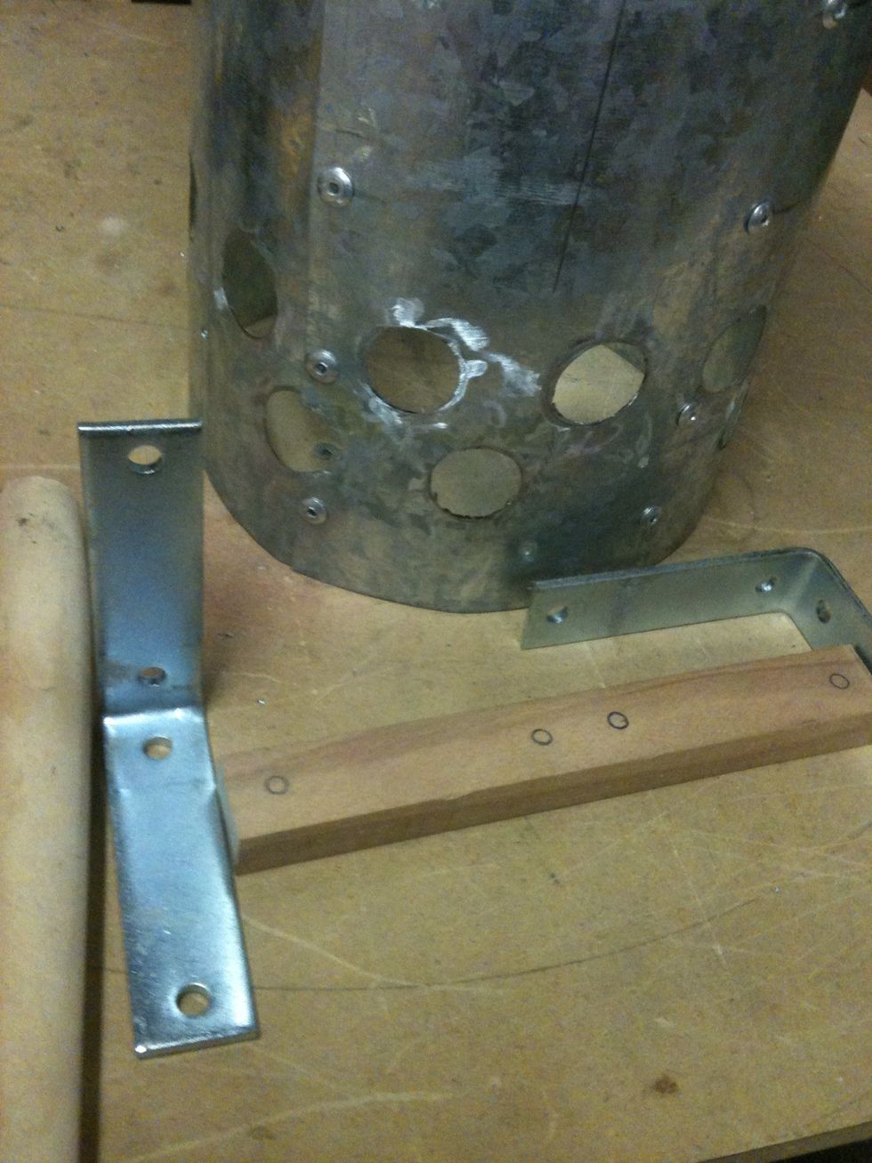 I marked the holes of the bracket to the piece of wood. I also marked the chimney where those holes go. I predrilled the piece of wood so it won't split and drill the holes in the chimney.