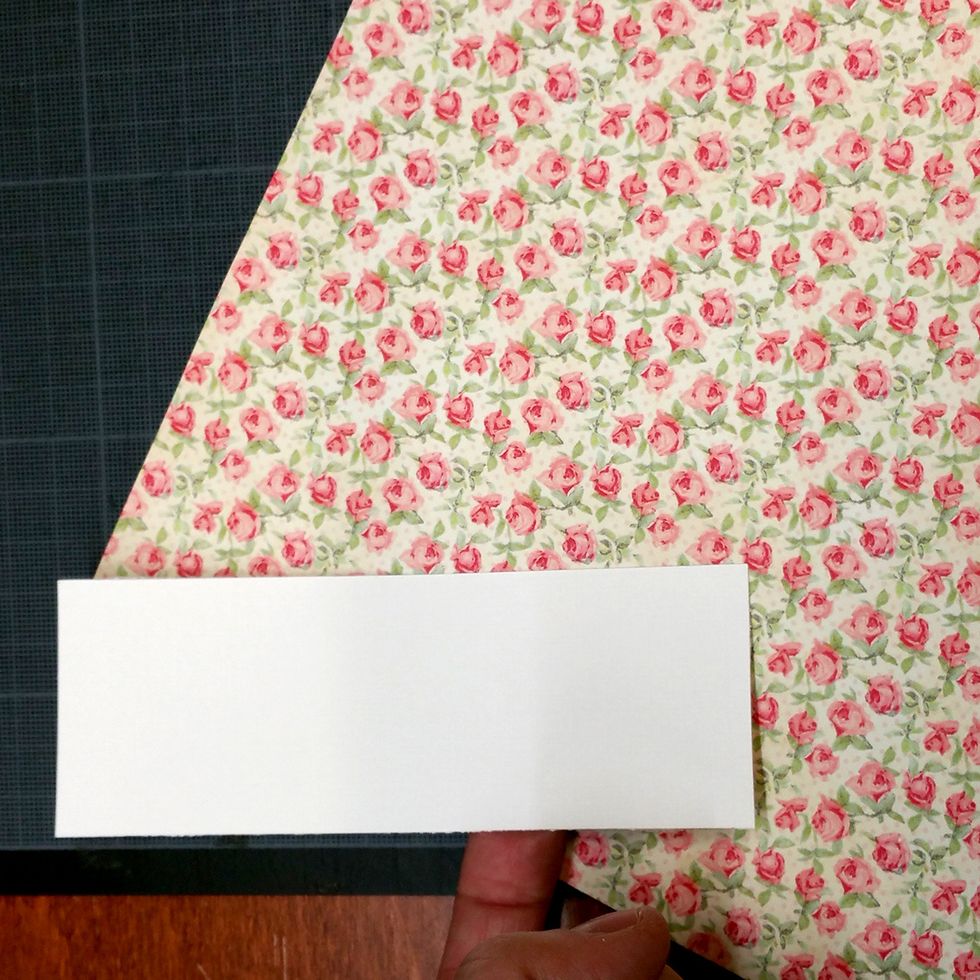 I measured the inside of the box. Then cut out a piece of white cardstock the correct width and twice the length. Then I glued some pattern paper to one of the sides of the white cardstock.