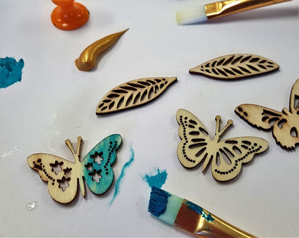 I painted the Kaiser Crafts wooden veneers shapes included in the ship with the teal-blue and gold acrylic paint...