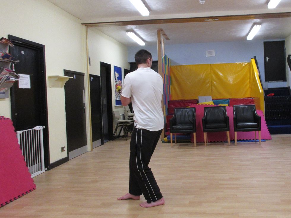 I pivot the front foot and draw the rear foot near as I prepare to kick. My heels are facing the target, and I aim at the opponent over my shoulder ready to turn into the kick.