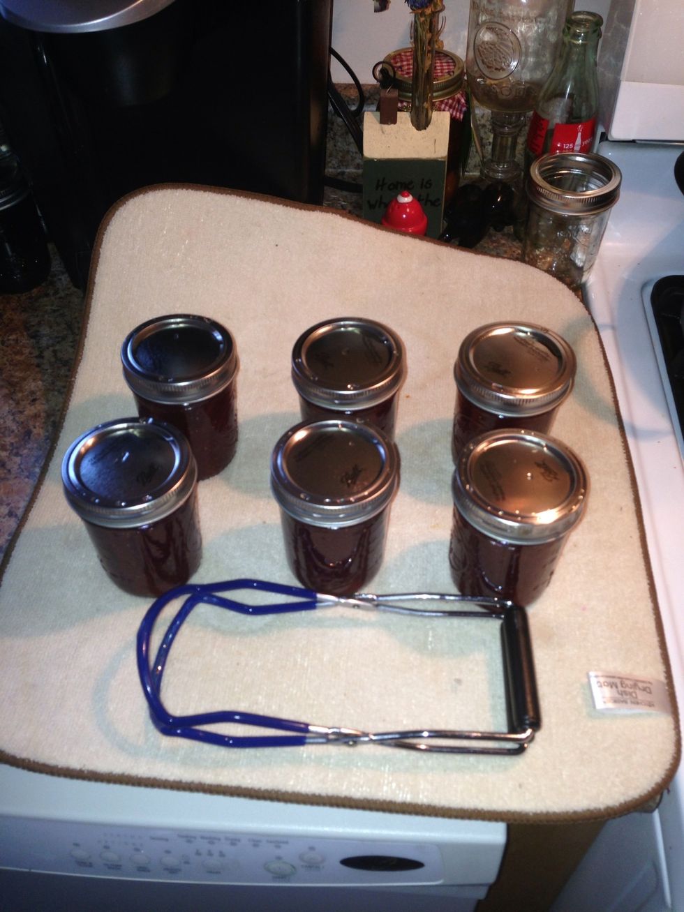 I place mine on a drying towel. You will notice a popping sound as they cool off. This is the lid sealing down. Once they cool off you should press on the center of the lids.