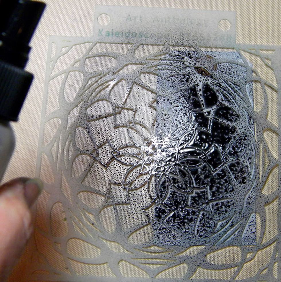 I placed the kaleidoscope stencil over one of the gray tags and sprayed more Raider over it.