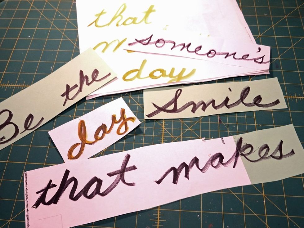 I practiced writing on scrap paper with both markers and paintbrushes. I cut strips for positioning. In the end, I use a ruler and paintbrush to write freehand across the canvas.