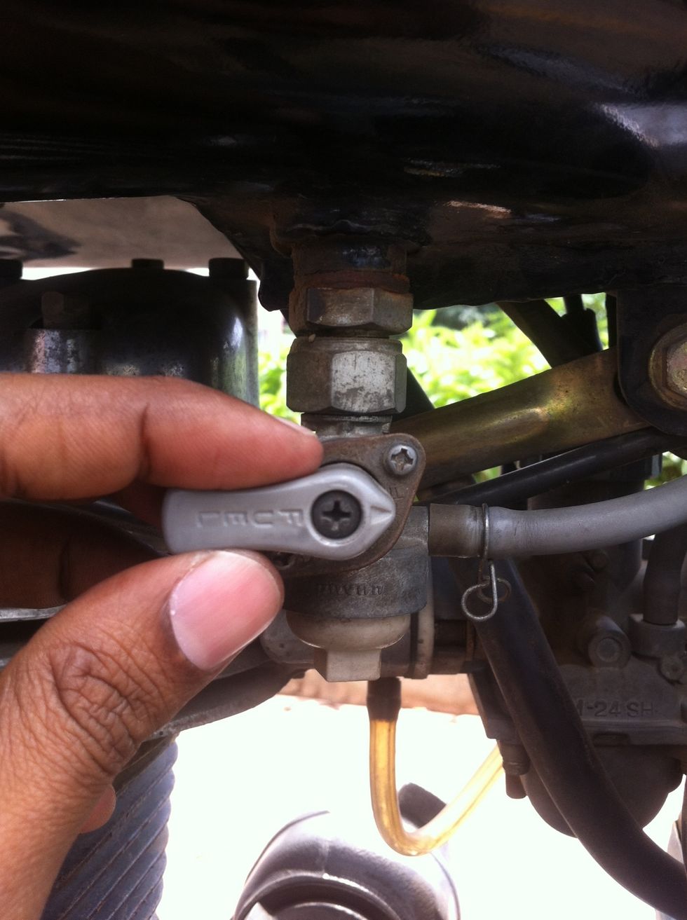 I prefer to remove the fuel tank for better access for routing the cable. Start by switching fuel off.