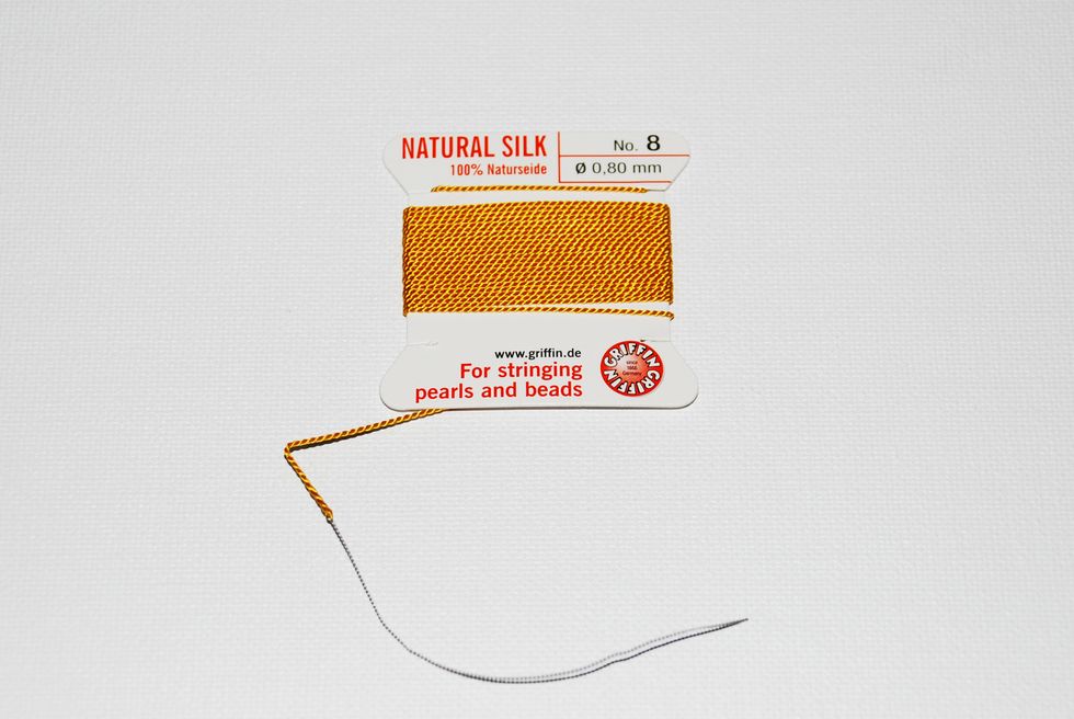 I prefer to use the Griffin Natural Silk Thread that comes on a card with an attached needle. Thickness No. of the thread will depend on the drilled hole size of your gems - so make sure to match it.