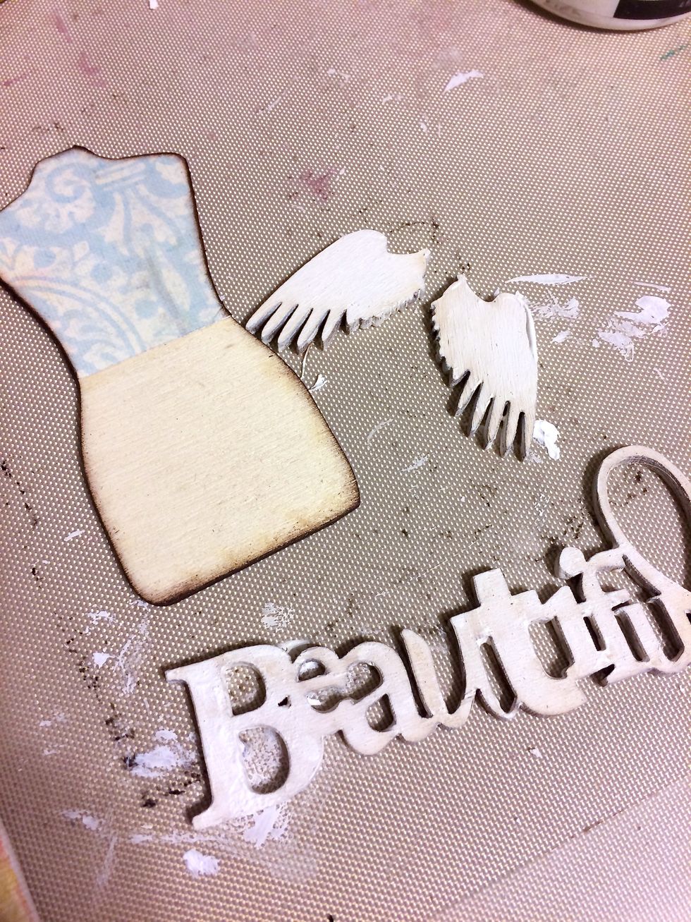 I prepared the wood pieces with gesso and collaged a pretty patterned paper onto the top portion of the dress form.