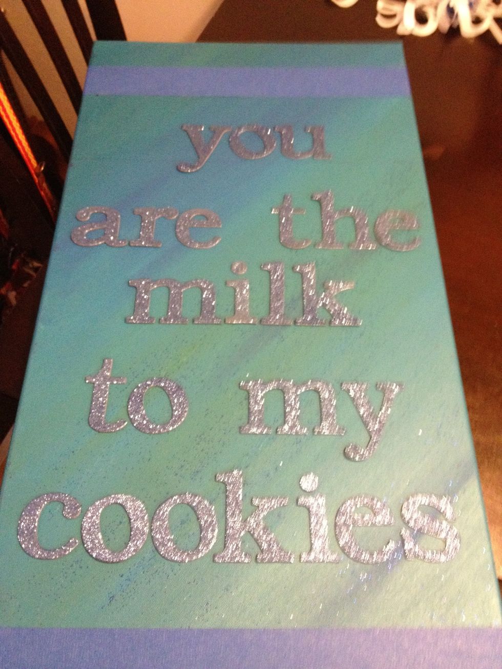 I pulled off the tape gently, and stuck the letters to the canvas. You want them to stick as best as possible so the spray doesn't leak underneath; mine did - but it came out with a cool effect...