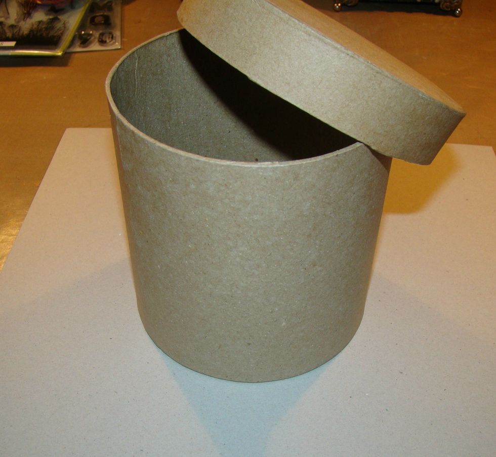 I purchased this paper mache box at Hobby Lobby with coupon it was only $2.  Get a piece of chipboard and cut a circle for the rim of your hat. I used a bowl as my template.