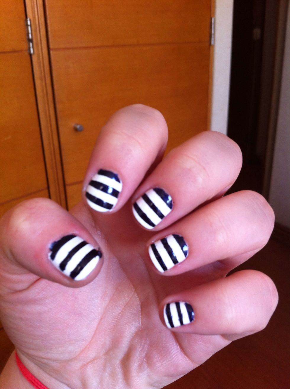 I recommend to do this nail by nail, so the scotch stays as less possible on each nail. Add a generous layer of blue polish and remove as soon as you've painted your nail, stripe by stripe, carefully.