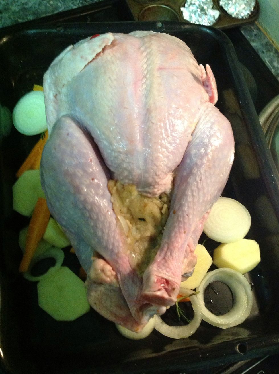 I rest the turkey on onions, potatoes, carrots. I add in thyme, rosemary and some water in the roasting pan. This forms the gravy. The fat and oils drip onto these vegetables.