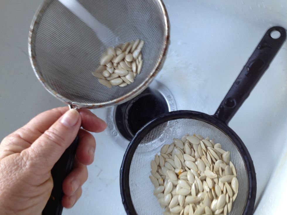 I rotate the seeds between two strainers. That makes it easier to clean them and prepare for roasting.