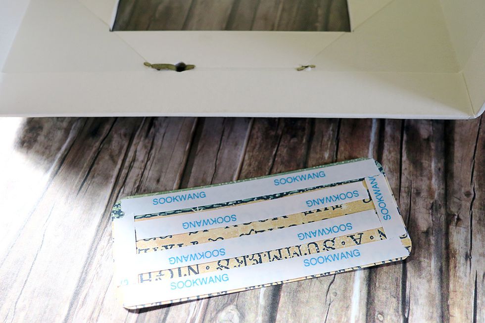 I suggest to cut another piece of the designer paper, to cover it with scor tape and glue it down, to cover the brads up.