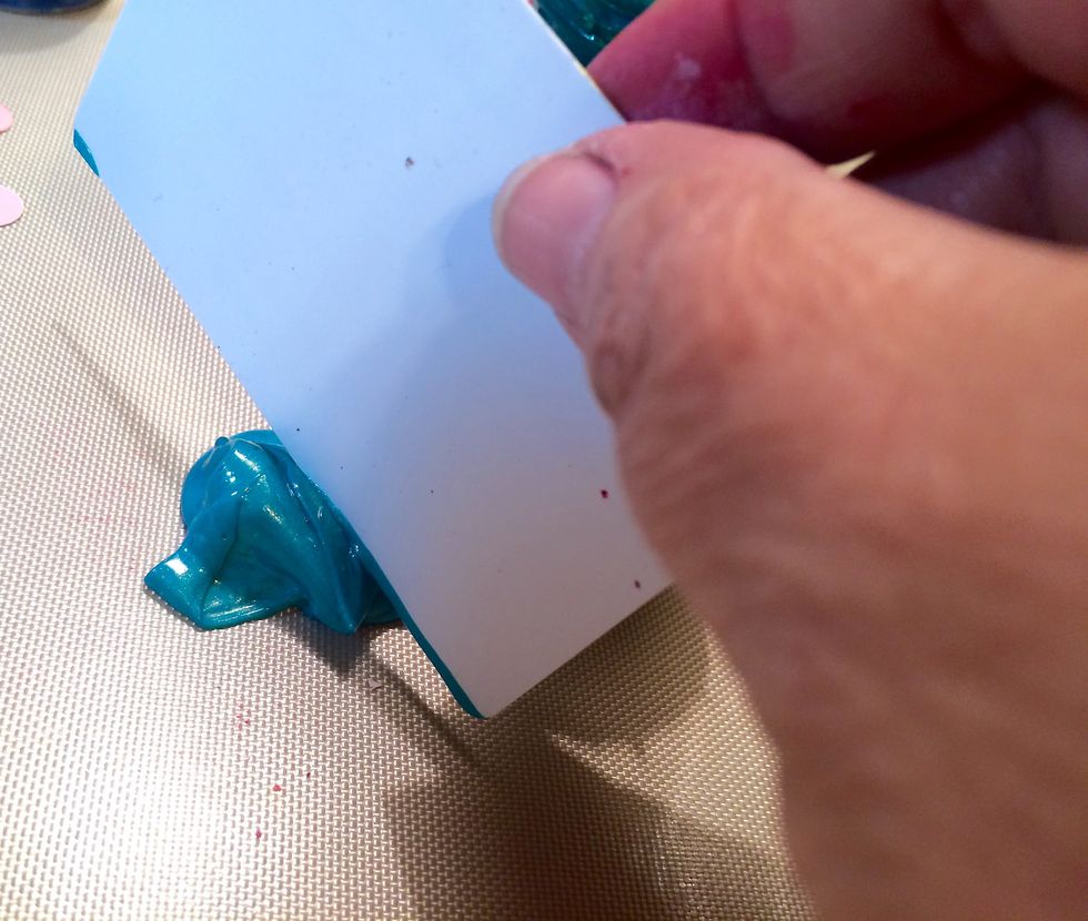 I take a card I've taken out of piece of junk mail and slide it across the Cayman Sorbet.