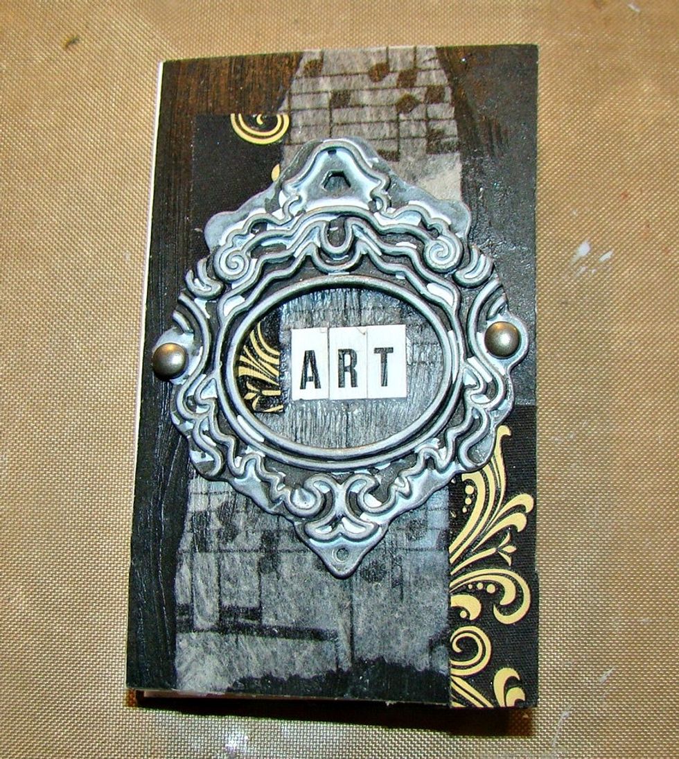 I Then added a mini metal frame and added the letters for my title. Brushed over with some gesso.