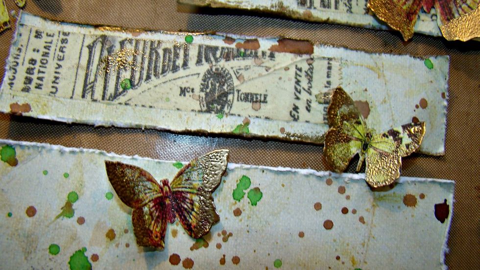 I then added the gold embossing powder to the wings of the butterflys and also some of the edges of my scraps of paper that will go under my photos.