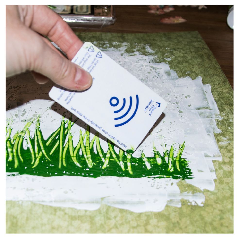 I then use an old credit card or hotel key to kind of drag the wet paint up, so it looks like grass. I make it turn different ways. That will make it look like the wind is blowing in the grass.