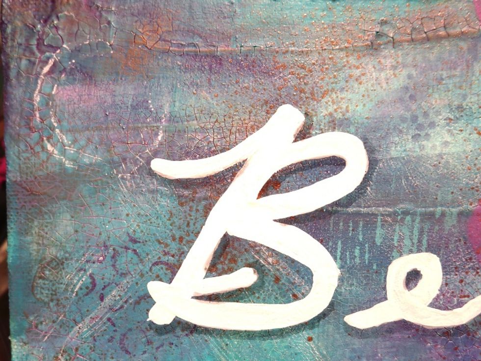 I thought the bright white letters were out of place on the canvas. I used a Faber Castell Pitt Pen in gray to add some shadow to the letters and they came alive. Much happier with them.